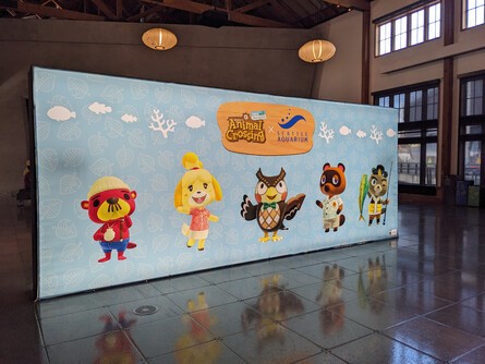 Animal Crossing character standees flank live aquarium exhibits