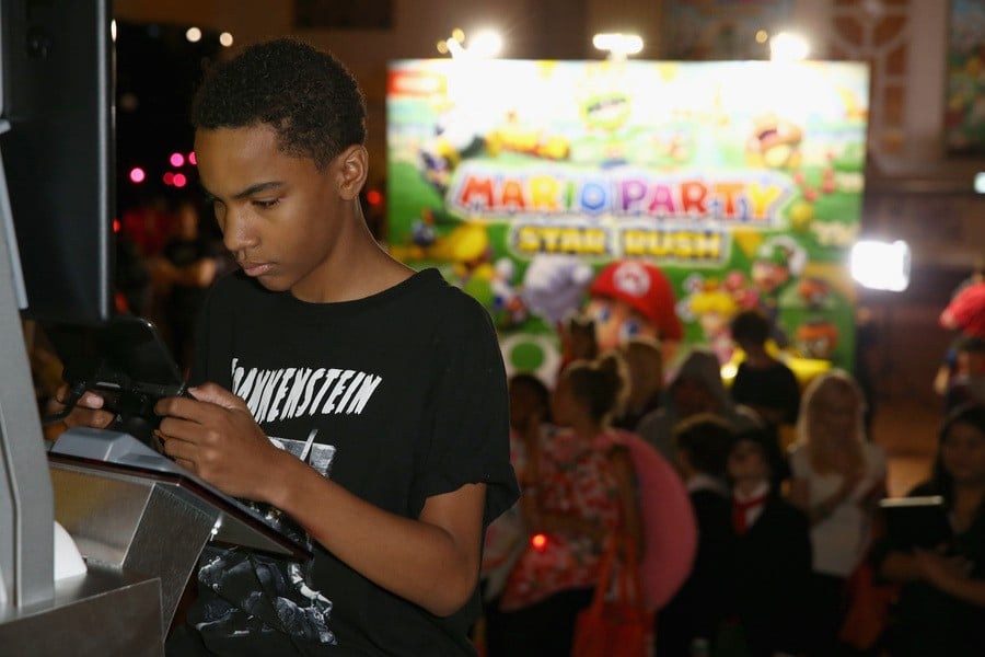 In this photo provided by Nintendo of America, actor Terrell Ransom Jr. plays a friendly round of competition in the Mario Party Star Rush game with guests at Starlight Children’s Foundation’s “Dream Halloween” event on Oct. 22 in Los Angeles.
