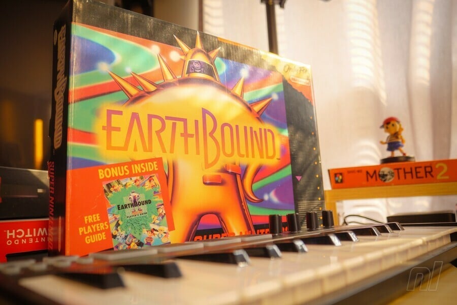 An EarthBound box sitting on a keyboard, because it wants to learn how to play music