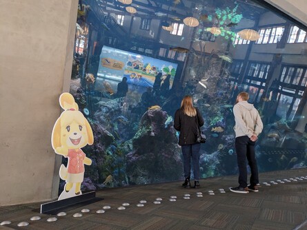 Animal Crossing character standees flank live aquarium exhibits