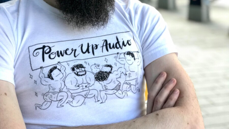 One of Power Up Audio's official T-shirts, featuring realistic drawings of all the members of the team