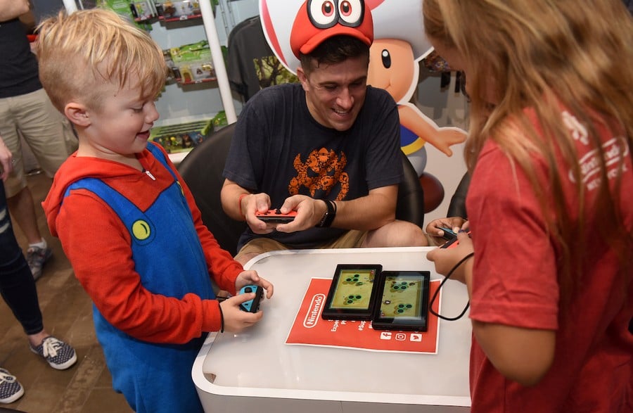 In this photo provided by Nintendo of America, Parker G., 7, Bill V. and Ava T., 8, left to right, of Rotterdam, NY, gather at the Nintendo NY store in Rockefeller Plaza to celebrate the launch of the Super Mario Party game by playing the new Toad’s Rec Room mode using two Nintendo Switch systems. An action-packed party game with 80 interactive mini-games, Super Mario Party is now available for the Nintendo Switch system.