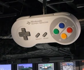 Giant Nintendo controllers and systems hang from the roof in this area