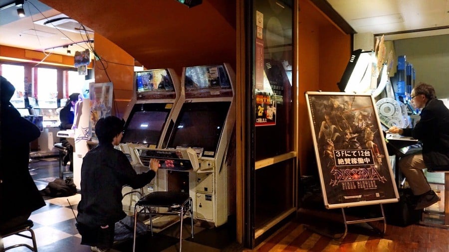 A staff member services a Sega Blast City cabinet in the Playland Carnival arcade in Shinjuku