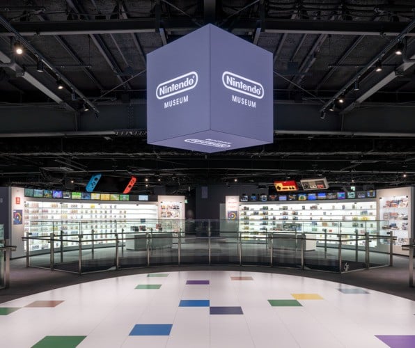 Giant Nintendo controllers and systems hang from the roof in this area